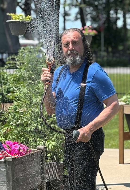 elder man spraying house playing with the camera person