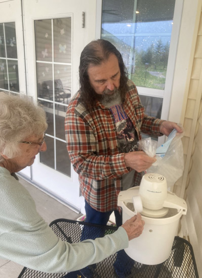 son dropping off gift for old lady